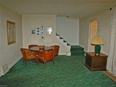 a living room with green carpet and white walls