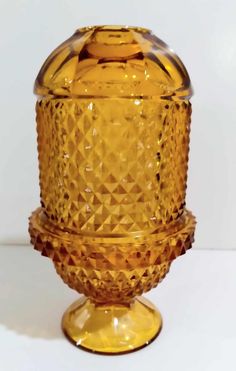 a yellow glass vase sitting on top of a table