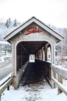 a covered bridge with snow falling on the ground