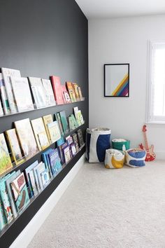 there are many books on the wall in this children's room that is organized