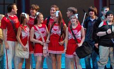 a group of young people standing next to each other on a stage in front of a crowd