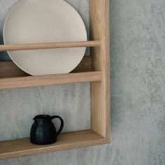 a white plate sitting on top of a wooden shelf