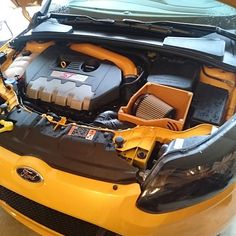 the engine compartment of a yellow sports car