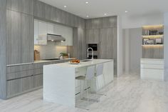 a large kitchen with marble counter tops and white cabinets