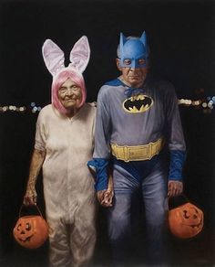 an older man and woman dressed up as batman and catwoman with jack - o'- lantern pumpkins