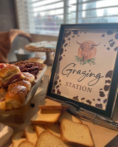 breads and pastries are displayed on a table with a sign that says grating station