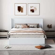 a white bed sitting in a bedroom next to two pictures on the wall above it