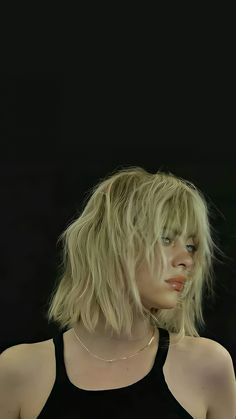 a woman with blonde hair wearing a black tank top