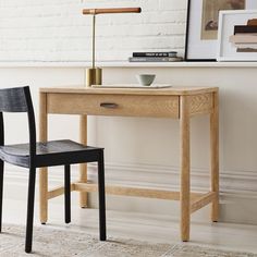 a wooden desk with a black chair next to it