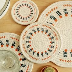 four placemats on a wooden table with plates and bowls next to them,