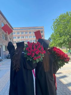 two graduates with flowers and books on their heads are standing in front of a building