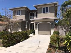 a two story house with garages and landscaping