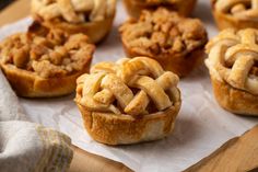 several small pies are sitting on top of a piece of parchment paper, ready to be eaten