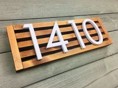 a wooden house number sign mounted to the side of a building