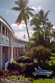 a pink building with white balconies and palm trees on the side of it