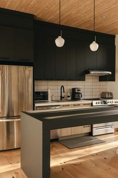 a kitchen with black cabinets and stainless steel appliances