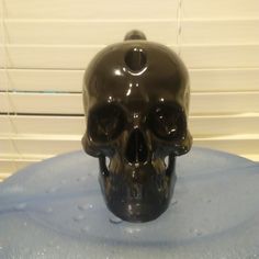 a black skull statue sitting on top of a blue table