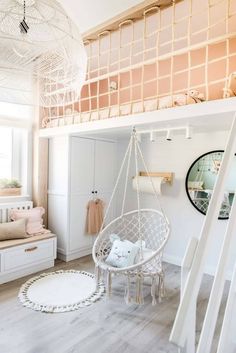 a room with white furniture and wooden floors, including a hammock chair hanging from the ceiling