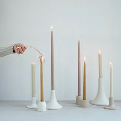 a person is lighting candles with one hand and the other in different positions to make them look like they are holding something