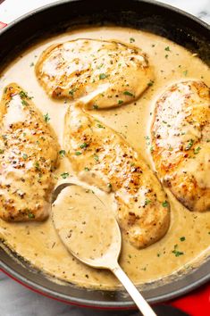 chicken with gravy in a skillet with a spoon