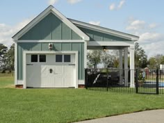 a white garage with a black gate in front of it and a pool behind it