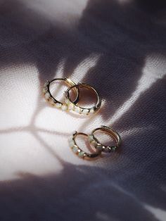 The prettiest white opal hoops to sweeten your earlobes. These gold and iridescent white opal huggie hoops shimmy and dance in the light day and night. Team them with with each other or mix and match with our other favorite hoop earrings. ✦ Choose your pair from two different sizes ✦✦ DETAILS ✦✧ Name: Ipolani (ee poh LAH nee) - heavenly sweetheart.✧ You will receive 1 pair.✧ Size 1: 10.5 x 2.25mm thick; 8.25mm inner diameter.✧ Size 2: 12.5 x 2.25mm thick; 9.75mm inner diameter.✧ Gold Plated Ster Gemstone Hoop Earrings, Small Gold Hoops, Iridescent White, Tiny Hoop Earrings, Gold Filled Hoops, Huggie Hoop Earrings, Cuff Earrings, Gold Hoops, White Opal