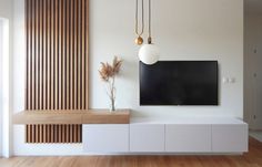 a flat screen tv mounted to the side of a wall next to a wooden cabinet