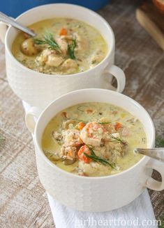 two white bowls filled with soup on top of a table