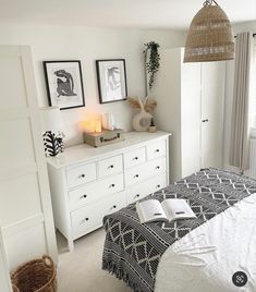 a bedroom with white furniture and pictures on the wall