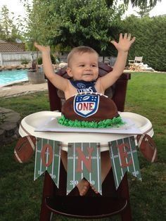 a baby sitting in a high chair with his hands up