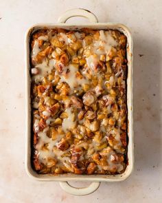 a casserole dish filled with meat and vegetables covered in gravy on a marble surface