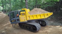 a large yellow bulldozer digging dirt in the woods