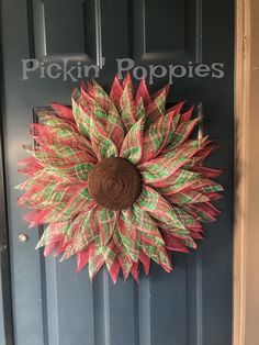 a red and green wreath hanging on the front door of a house that says pickin'popsies