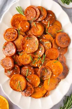 a white plate topped with cooked carrots and rosemary