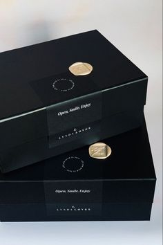 two black boxes with gold coins in them sitting side by side on top of each other