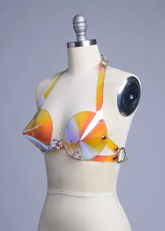 This bullet bra, or "cone bra" is inspired by retro pin-up vixens. This is the iridescent holographic version! Halter style straps. Buckles in front, back, and behind the neck. Silver-toned nickel plated hardware. Holes reinforced with grommets. Available in Sunset PVC (shown) or Blue PVC. Both colors are transparent. Sunset shifts warm over light colors, shifts blue over darker colors. Blue shifts cool over light colors, and warm over darker colors. Fits up to a DD cup - custom sizing available Futuristic Photoshoot, Futuristic Costume, Bra Art, Alien Clothes, Gogo Dancer, Bullet Bra, Retro Pin Up, Seductive Clothes, Glow Party