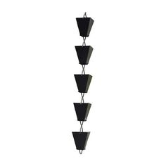 a tall metal planter with four black pots hanging from it's sides on a white wall