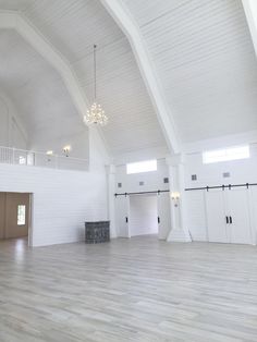 an empty room with white walls and wood floors