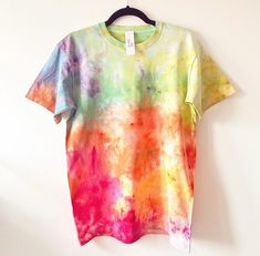 a colorful t - shirt hanging on a white wall