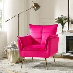 a bright pink chair sits in front of a fireplace