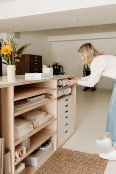 a woman standing in front of a wooden cabinet