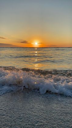 the sun is setting over the ocean waves