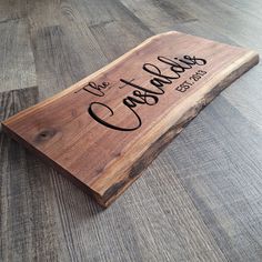 a wooden cutting board with the words we love cats and dogs engraved on it sitting on a wood floor