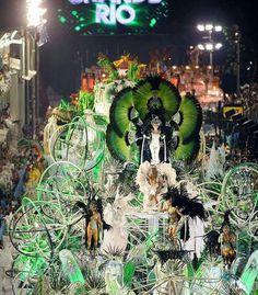 a parade float in the middle of a street at night with lots of green and white decorations