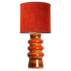 an orange lamp with a red shade on it