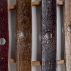 four wooden sleds are lined up in a row with holes on the sides