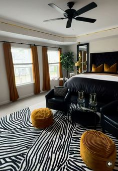 a black and white bedroom with zebra print rugs on the floor, two yellow footstools