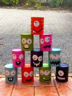 a bunch of cups that are sitting on a brick floor with faces painted on them