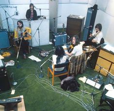 a group of people in a room with guitars