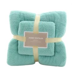 three teal towels wrapped in yellow ribbon and tied to each other with a tag that says home textiles